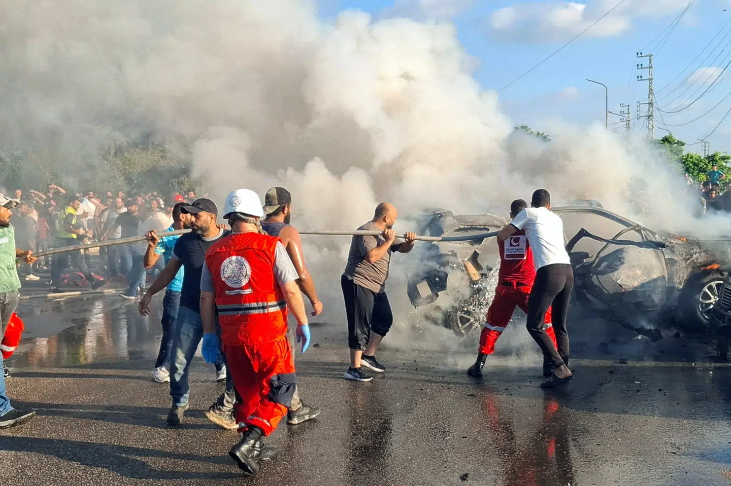 Civile og medlemmer af beredskab forsøger at slukke brand i bil i Sidon efter et tilsyneladende israelsk flyangreb. Første melding lyder, at et medlem af Hamas fra en nærliggende flygtningelejr er dræbt ved angrebet.