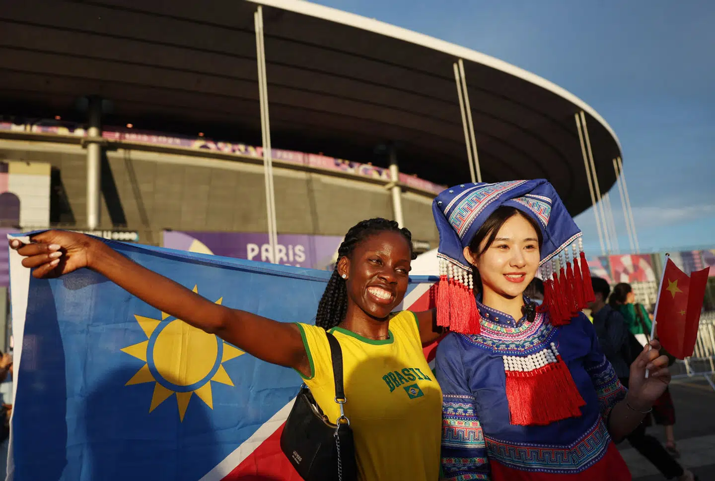 Tilskuere poserer foran Stade de France i Paris før De Olympiske Leges slutceremoni søndag aften.