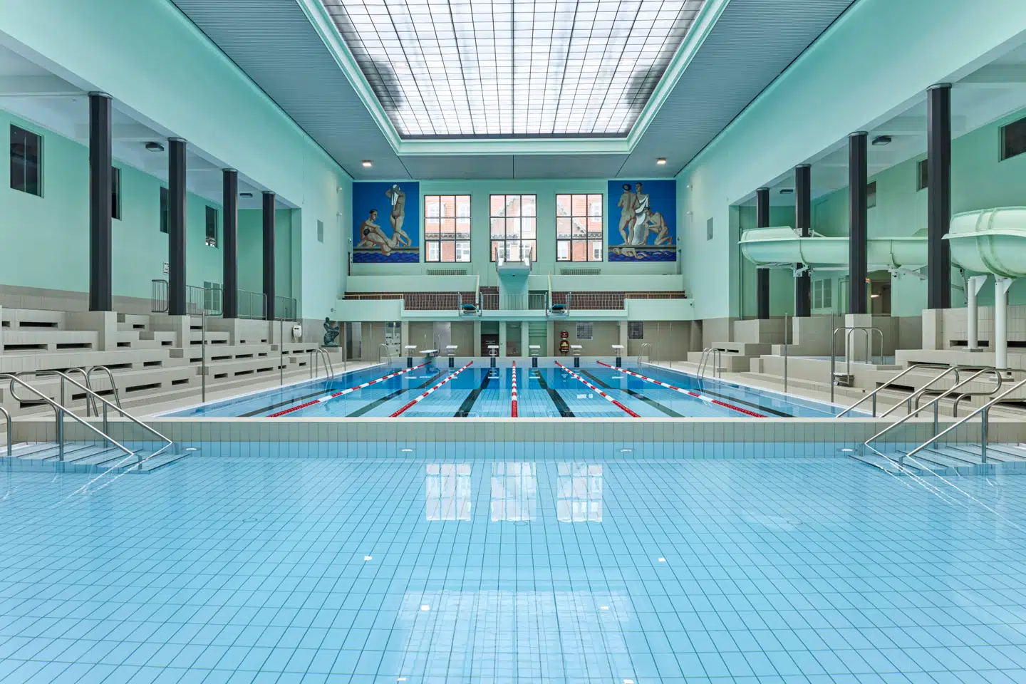 Den kølige mintgrønne farve, den rolige takt og de knivskarpe upyntede aftrapninger hæver Frederiksberg Svømmehal op til mere end bare et svømmebassin. Og så er der selvfølgelig mosaikkerne!