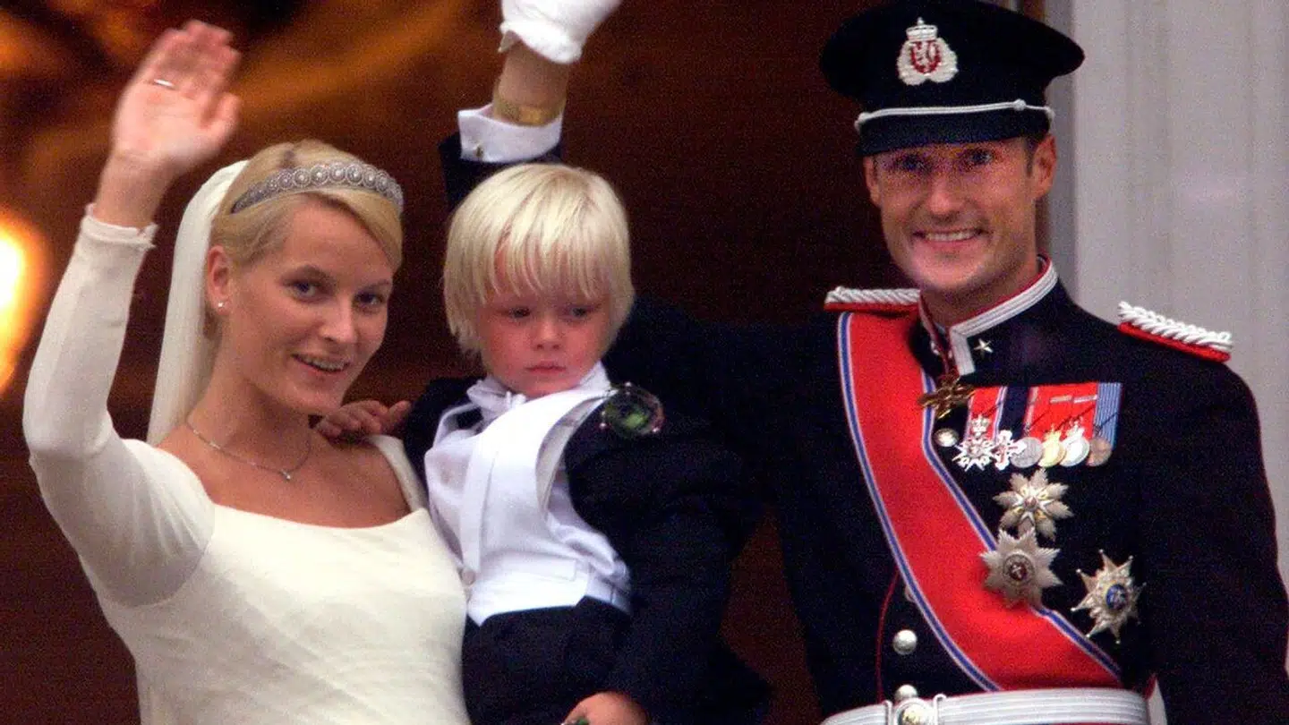 Norwegian Crown Prince Haakon (R) and his bride Mette-Marit Tjessem Høiby who is holding her son Marius in her arms, wave from the balcony of the Royal Palace after their wedding in Oslo August 25, 2001. Norway ´s Crown Prince Haakon married a modern-day Cinderella in Oslo as thousands of Norwegians cheered in forgiving mood for their future queen ´s wild partying past. Marius is Mette Marit ´s son from a previous marriage. REUTERS/Jerry Lampen
