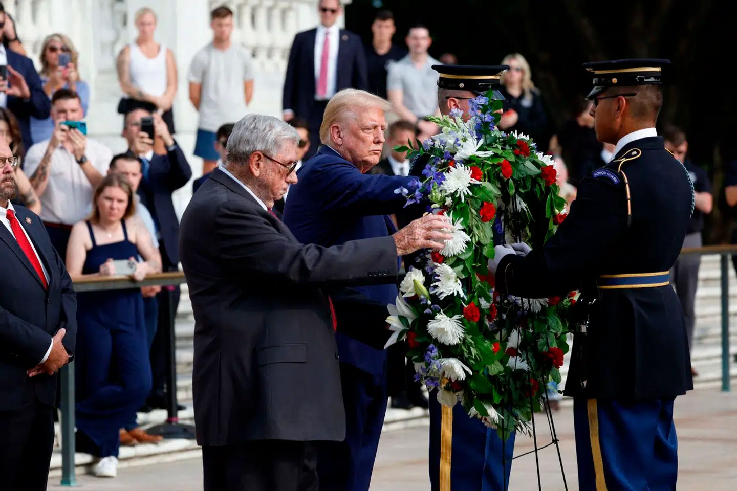 ARLINGTON, VIRGINIA – AUGUST 26: Republican presidential nominee, former U.S. President Donald Trump stands alongside Bill Barnett (L), WHO's grandson Staff Sgt Darin Taylor Hoover died in Abbey Gate Bombing, during a wreath laying ceremony at the Tomb of the Unknown Soldier at Arlington National Cemetery on August 26, 2024 in Arlington, Virginia. Monday marks three years since the August 26, 2021, suicide bombing at Hamid Karzai International Airport, which killed 13 American service members. Anna Moneymaker/Getty Images/AFP (Photo by Anna Moneymaker / GETTY IMAGES NORTH AMERICA / Getty Images via AFP)