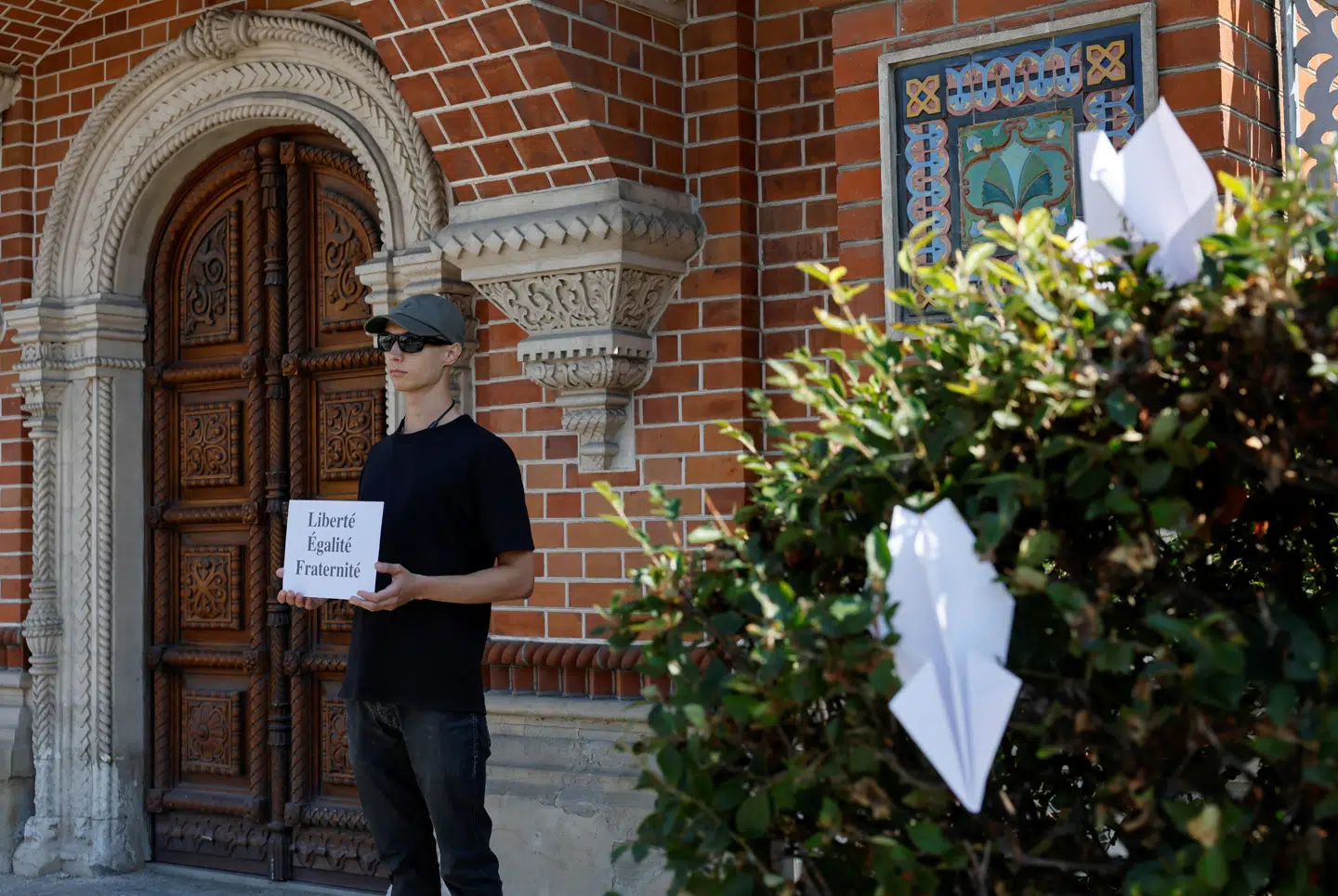 En enlig demonstrant protesterer mod anholdelsen af Pavel Durov foran den franske embassade i Moskva. Papirflyene i hækkene henviser til Telegrams logo. Foto: Yulia Morozova, Reuters, Scanpix.