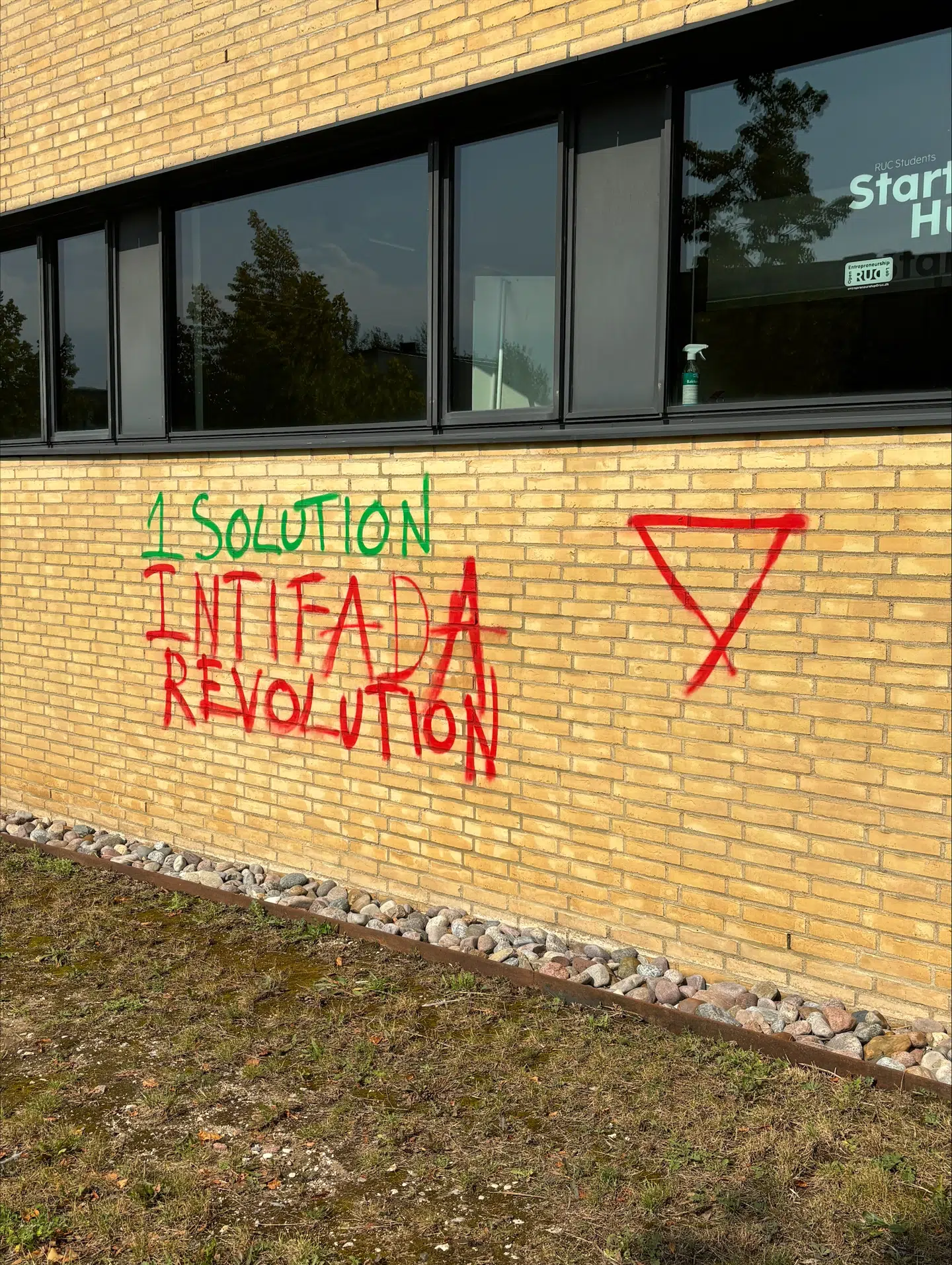 Sloganet »1 solution, Intifada revolution« er en reference til tidligere voldelige palæstinensiske oprør præget af terrorangreb mod Israel. Ved siden af sloganet er malet en rød trekant, som ofte anvendes til at udtrykke støtte til Hamas.