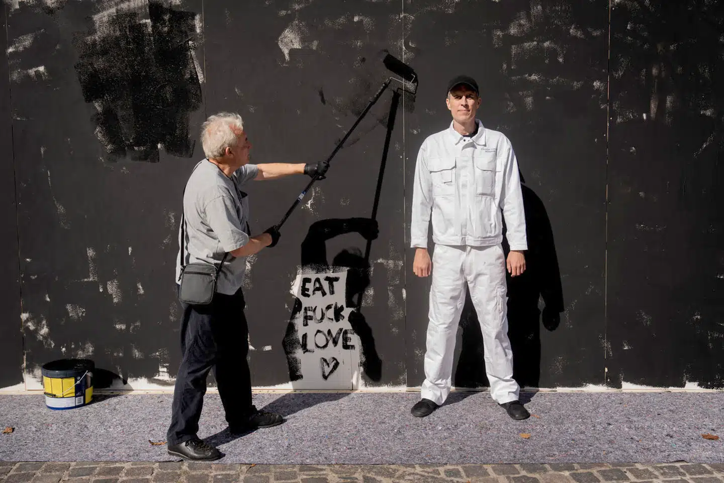 Christian Falsnaes i hvidt tøj ved værket ARBEJDSTID. Fotografen Stuart McIntyre kom tilfældigt forbi og er godt i gang med at levere en ordentlig arbejdsindsats.