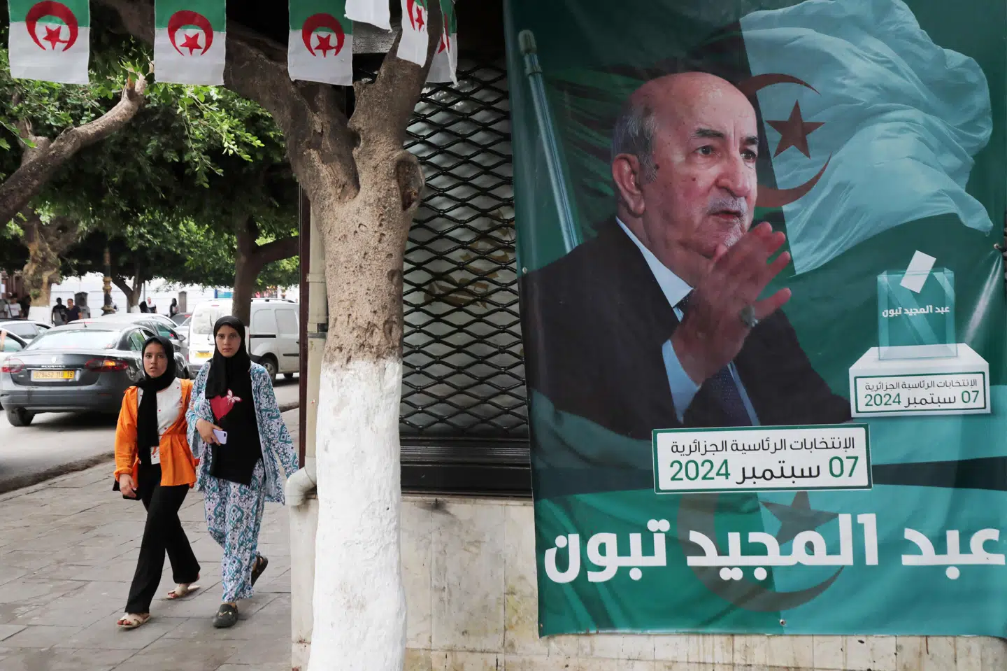 Folk går forbi valgplakat med Algeriets genvalgte præsident, Abdelmajid Tebboune. Den 78-årige Tebboune er blevet genvalgt med 84,3 procent af stemmerne, viser det endelige valgresultat fra valget i sidste uge. Det oplyser forfatningsdomstolen lørdag ifølge AFP.