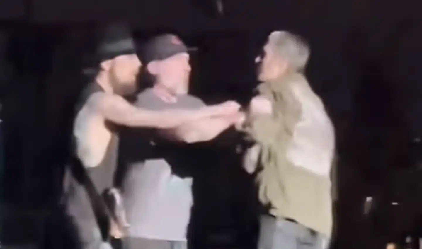 En sikkerhedsvagt lægger sig imellem.