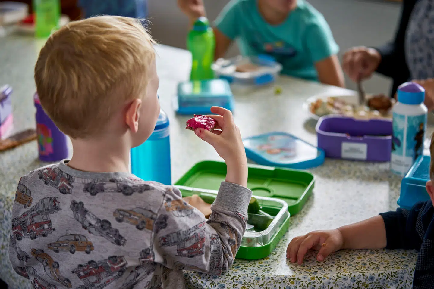 Børn sidder ved et bord og spiser frokost. Børnehave i Kalundborg den 22 juni 2021