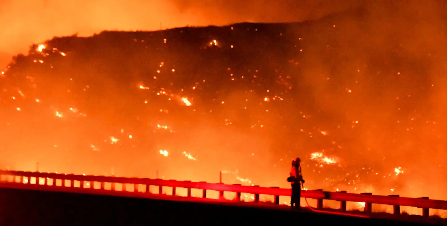 En brandmand står foran et flammehav nord for Los Angeles.