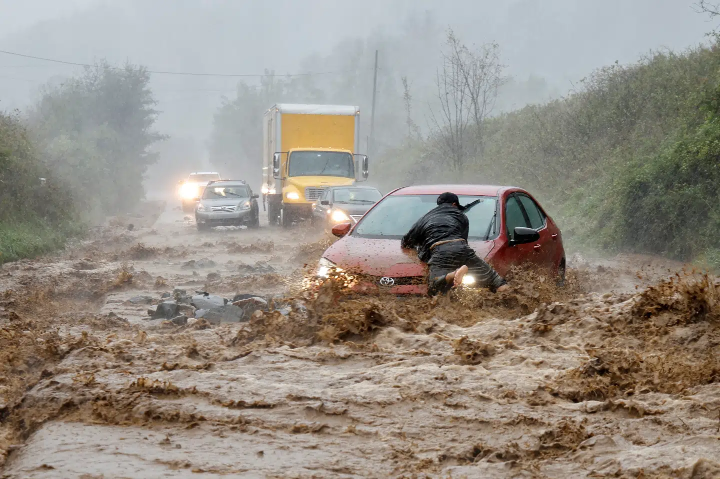 Borgere hjælper med at få bil fri i North Carolina under stormen Helene.