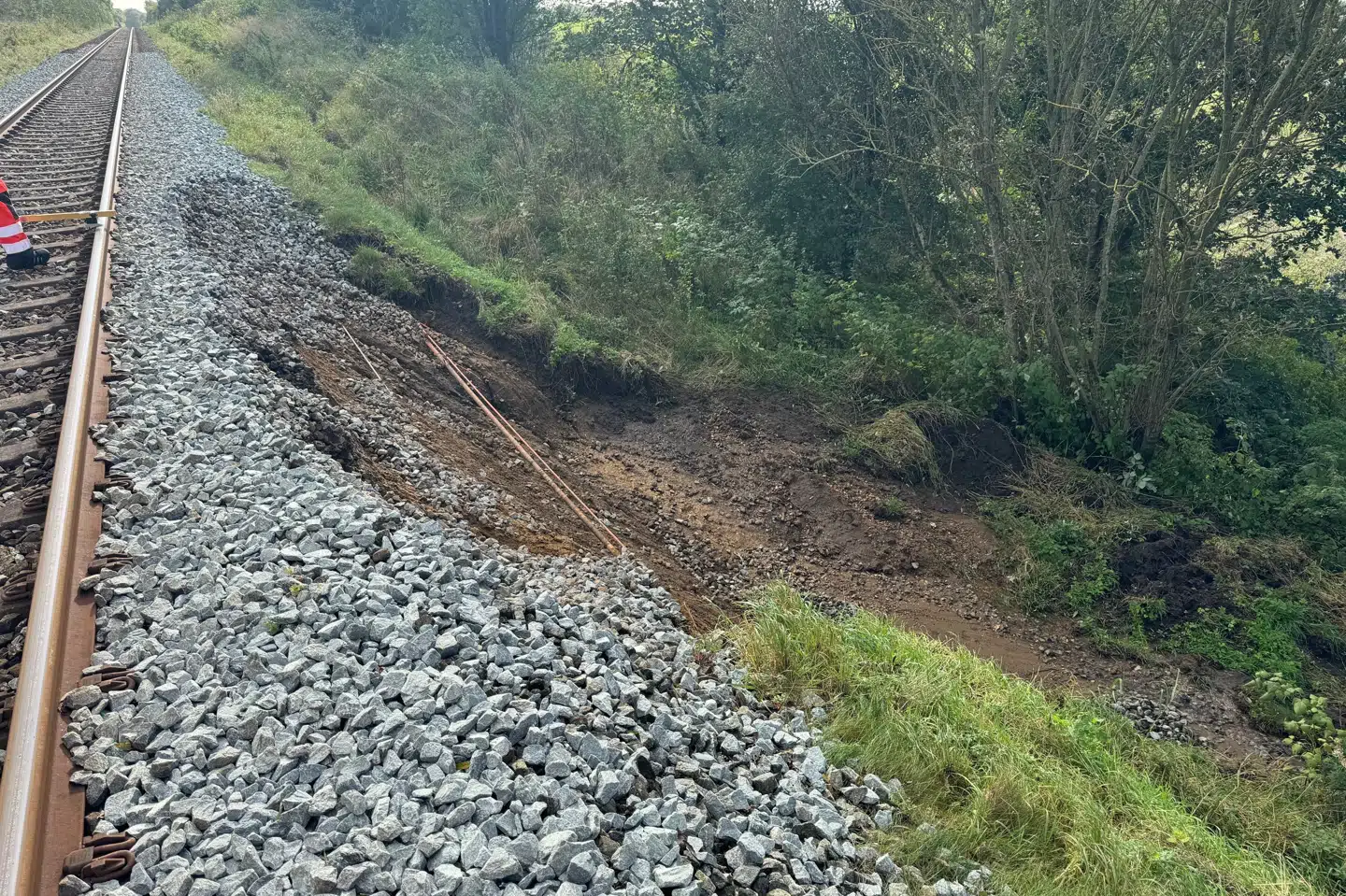 Dæmningsskred ved Gadbjerg vest for Jelling betyder, at der i øjeblikket ikke kører tog mellem Vejle og Give. Billedet af skreddet er taget af Banedanmark.