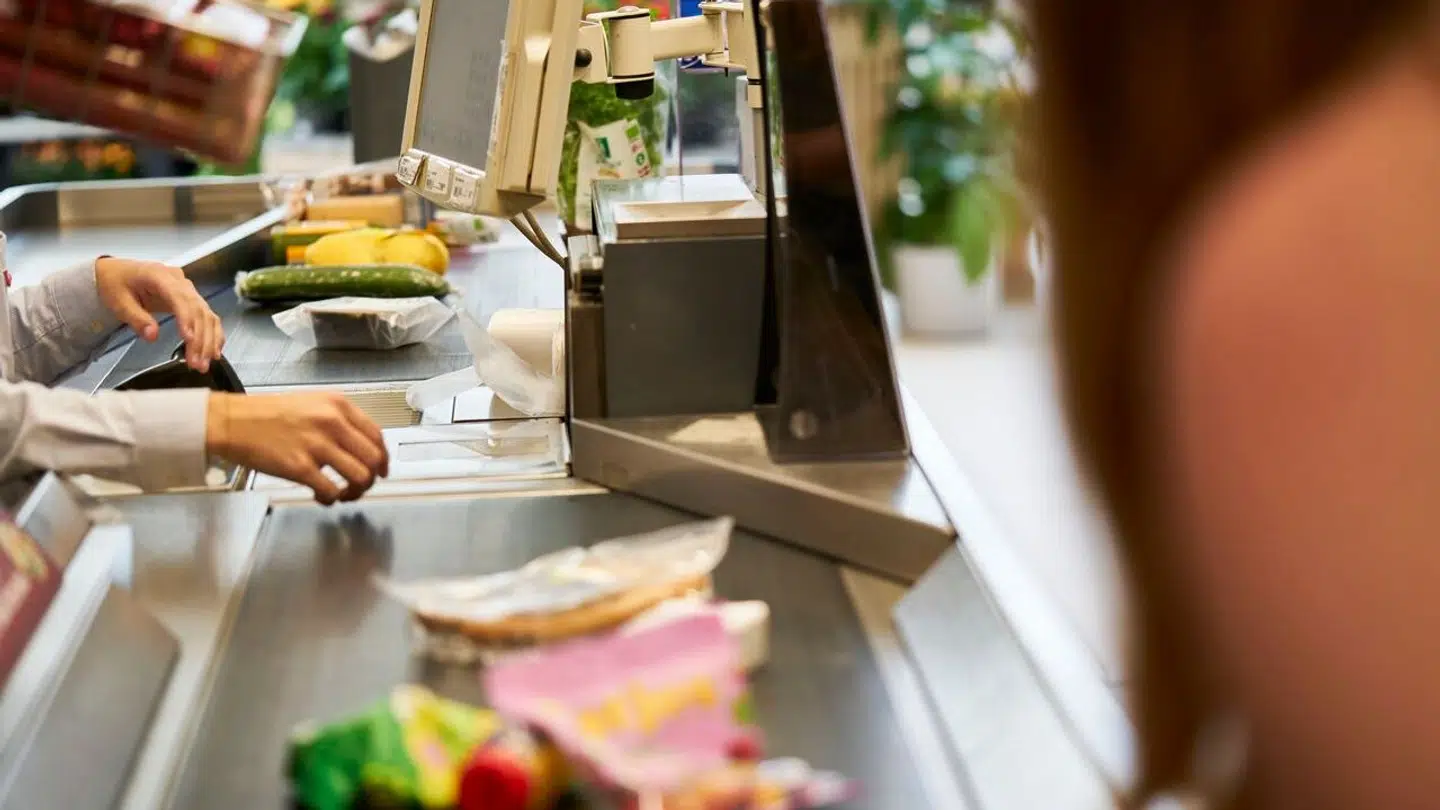 Her ses kunde, der har lagt varer på båndet ved kassen i et af landets supermarkeder.