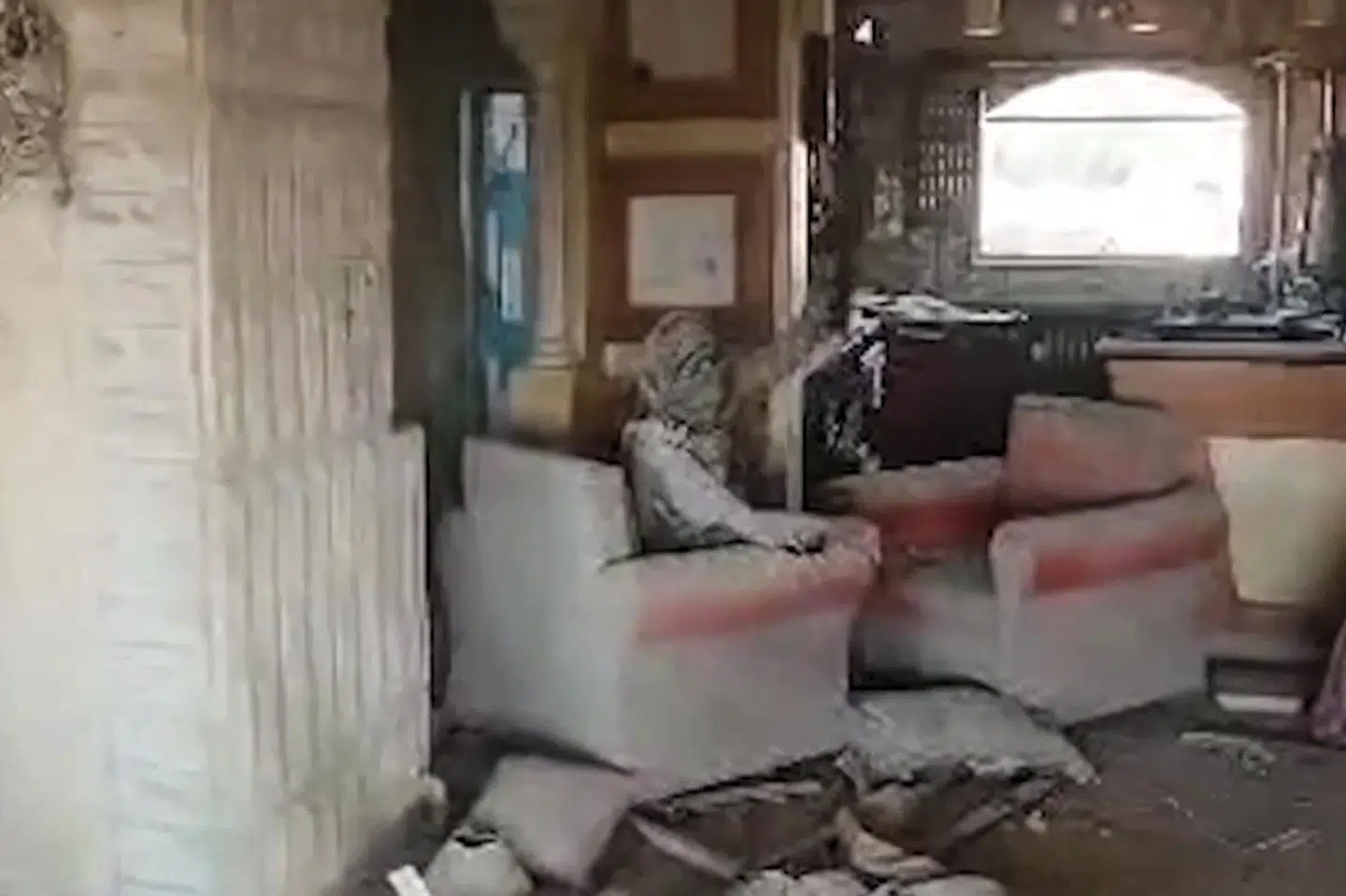 Et billede fra videoen af Sinwar, der hårdt såret kæmper videre. Det foto vækker stolthed hos palæstinensere, som Reuters har talt med.