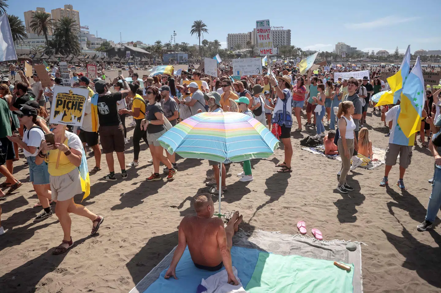 Demonstranter ses på Playa de Las Americas under en demonstration mod masseturisme på Tenerife søndag.