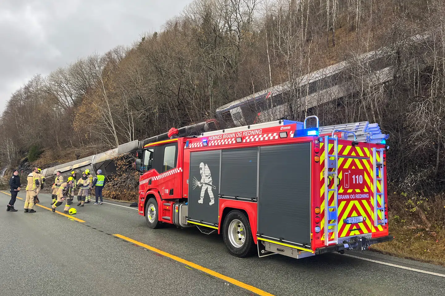 Redningsmandskab arbejder ved Finneidfjord i Nordland i Norge torsdag eftermiddag, hvor et tog er kørt af sporet. Politiet mener umiddelbart, at et stenskred er skyld i ulykken.