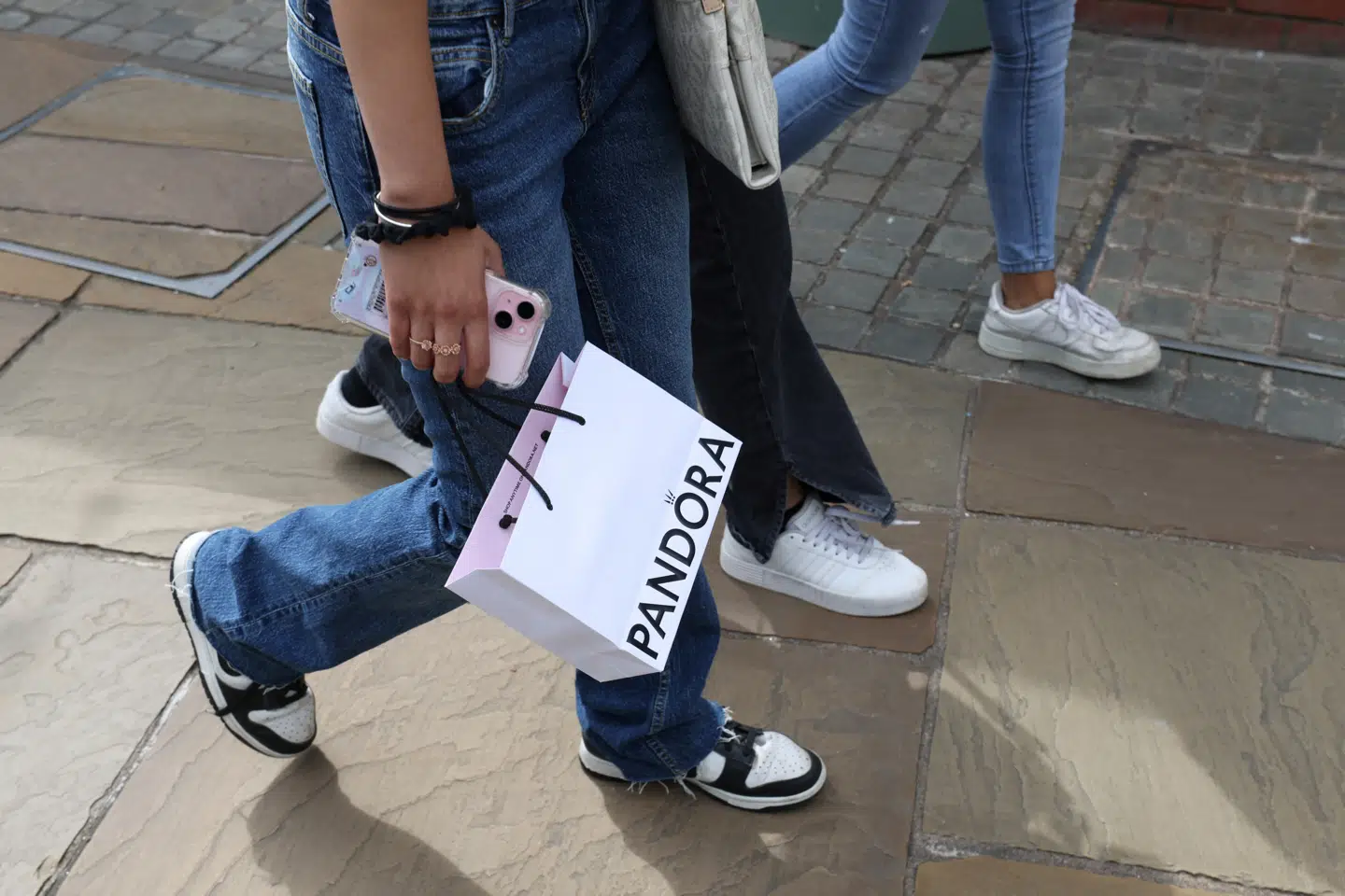 A shopper carries a Pandora shopping bag at Bicester Village in Oxfordshire, Britain, August 21, 2024. REUTERS/Hollie Adams
