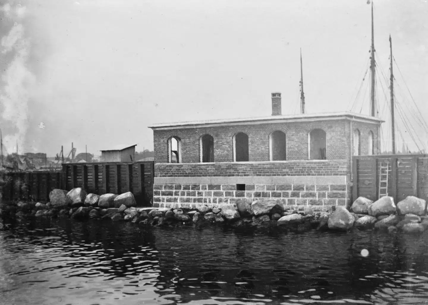 Sådan så bygningen ud, inden den blev pakket ned – og sådan kommer den til at se ud igen, dog med lidt mere moderne omgivelser.