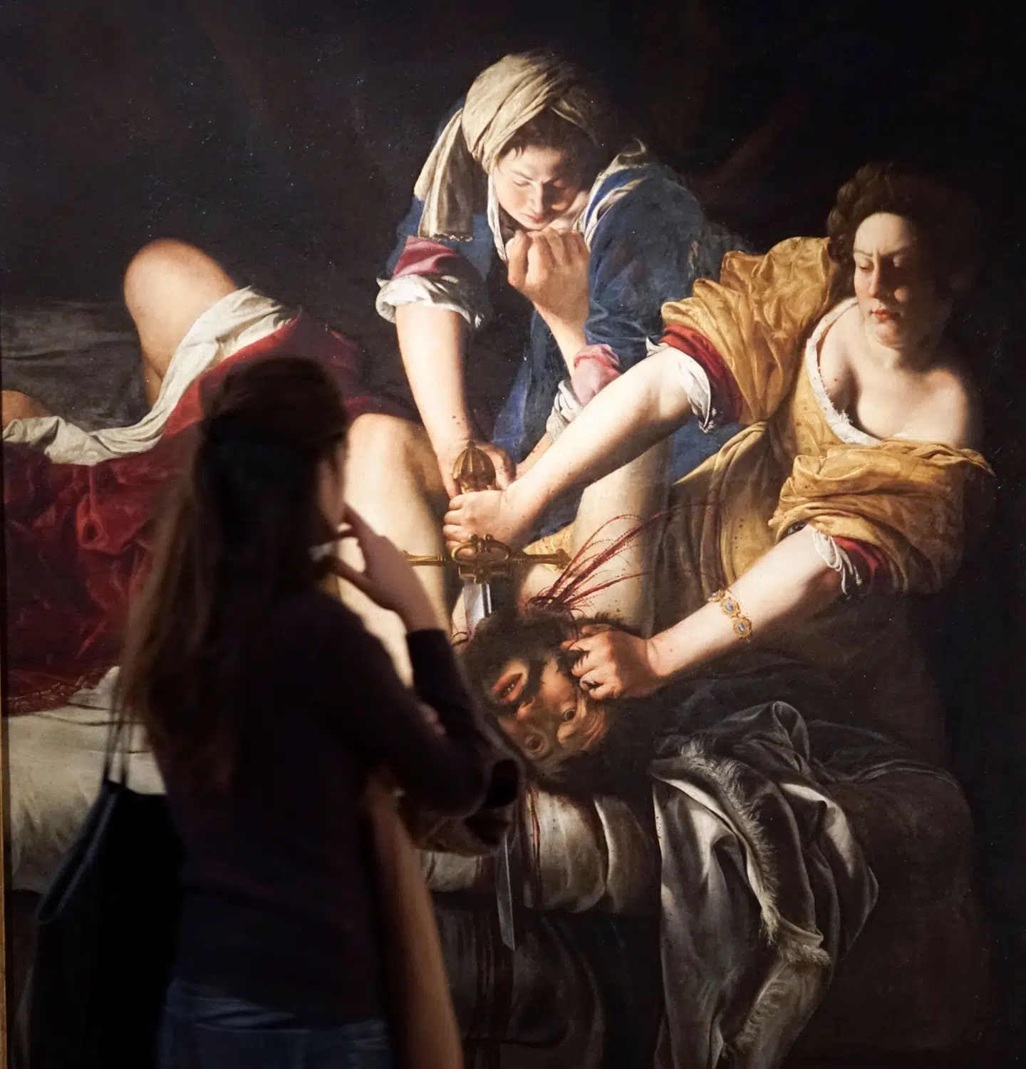 En kvinde beskuer »Judith dræber Holofernes« af den kvindelige 1600-talskunstmaler Artemisia Gentileschi.