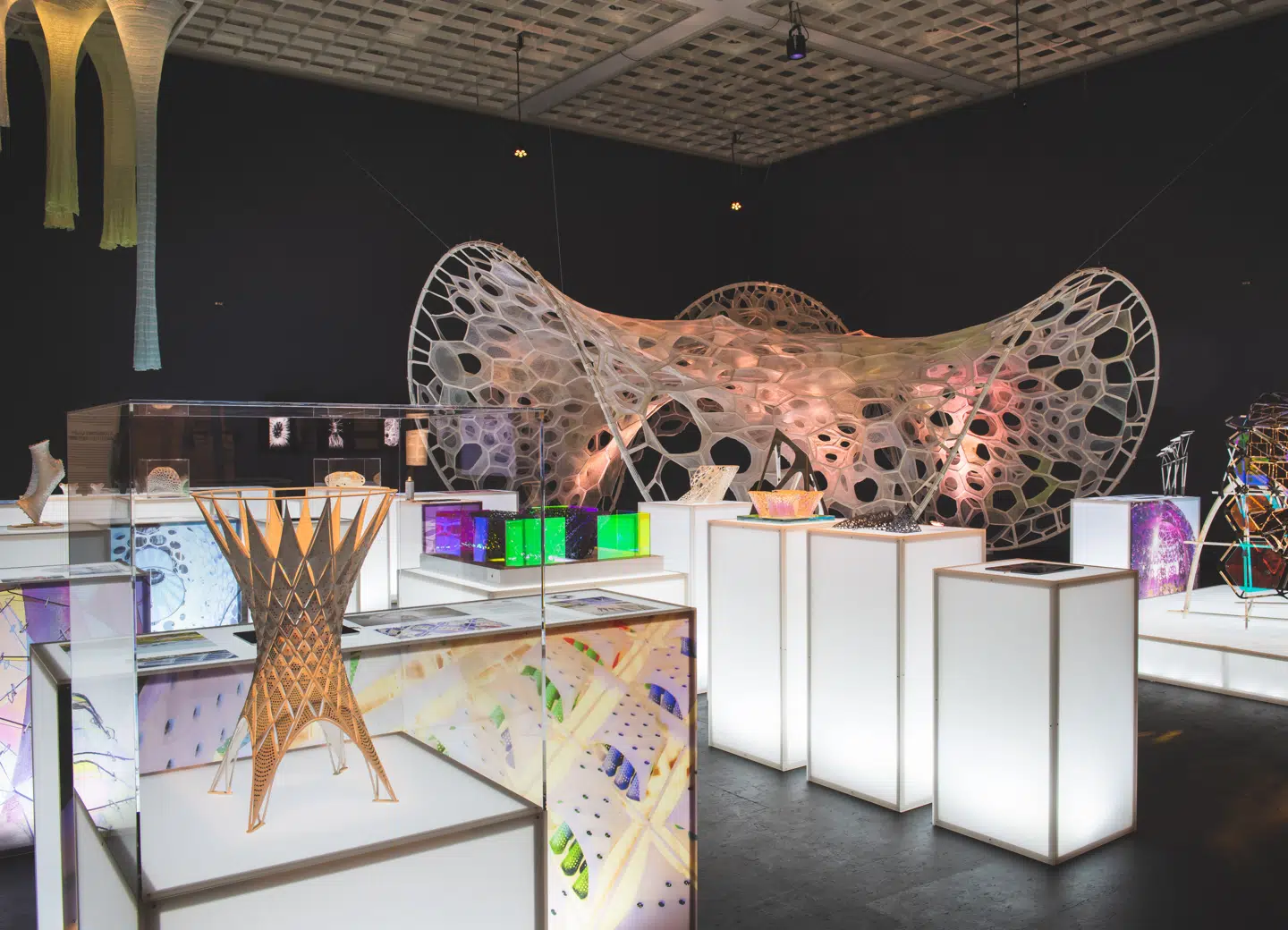 Jenny Sabin Studios PolyThread-objekt, som ses i baggrunden her, er digitalt vævet i en proces, der efterligner biologiens cellestrukturer. Stoffet kan både optage og afgive lys.