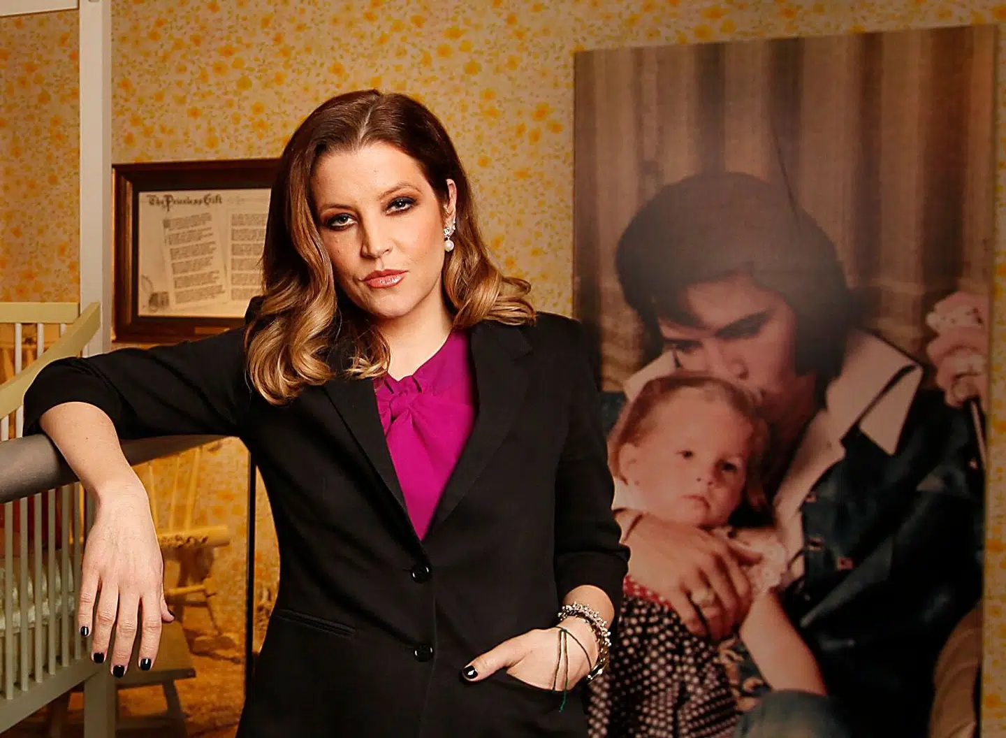 FILE - Lisa Marie Presley stands next to her childhood crib displayed with other mementos in the new exhibit "Elvis Through His Daughter's Eyes, " at Graceland in Memphis, Tenn., Jan. 31, 2012. On Thursday, Jan. 26, 2023, Priscilla Presley filed legal documents disputing who oversees the estate of her late daughter Lisa Marie Presley. The singer and only child of Elvis Presley, died at a hospital at age 54 on Jan. 12. (AP Photo/Lance Murphey, File)