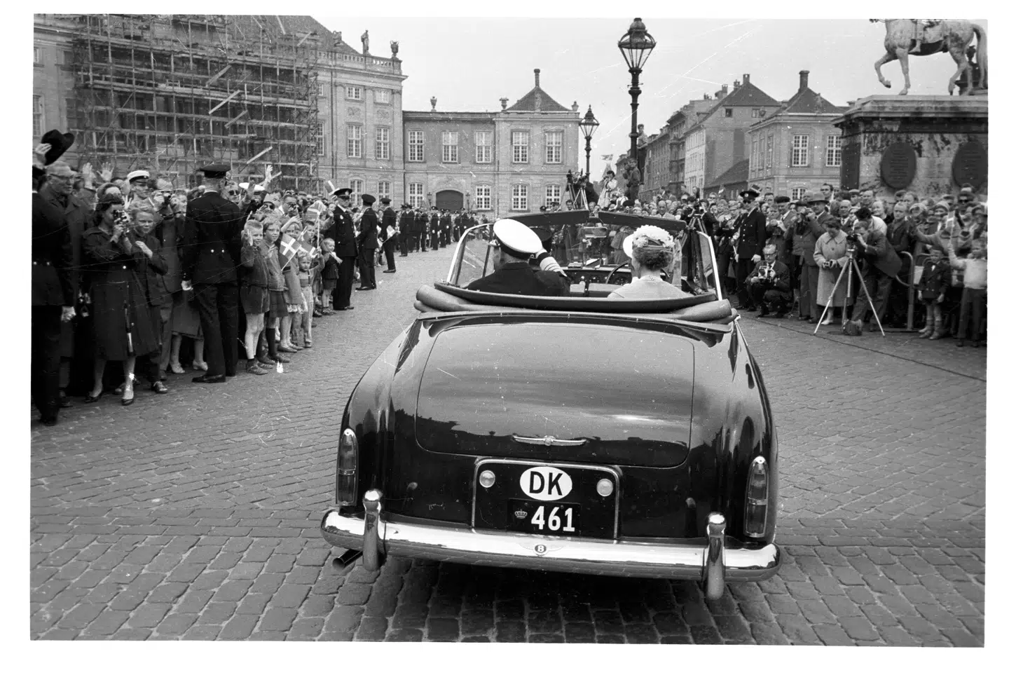 Kong Frederik IX og dronning Ingrid sølvbryllup d. 24. maj 1960. Kronebilen er på vej fra Fredensborg til København. Kong Frederik IX er selv chauffør med dronning Ingrid på forsædet. Chaufføren har fået pladsen på bagsædet.