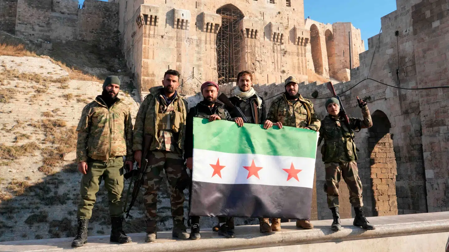 Oprørere poserer med deres flag foran det berømte citadel i Aleppo.