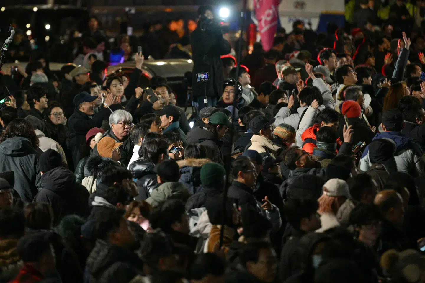 Demonstranter ses her uden for den sydkoreanske nationalforsamling.