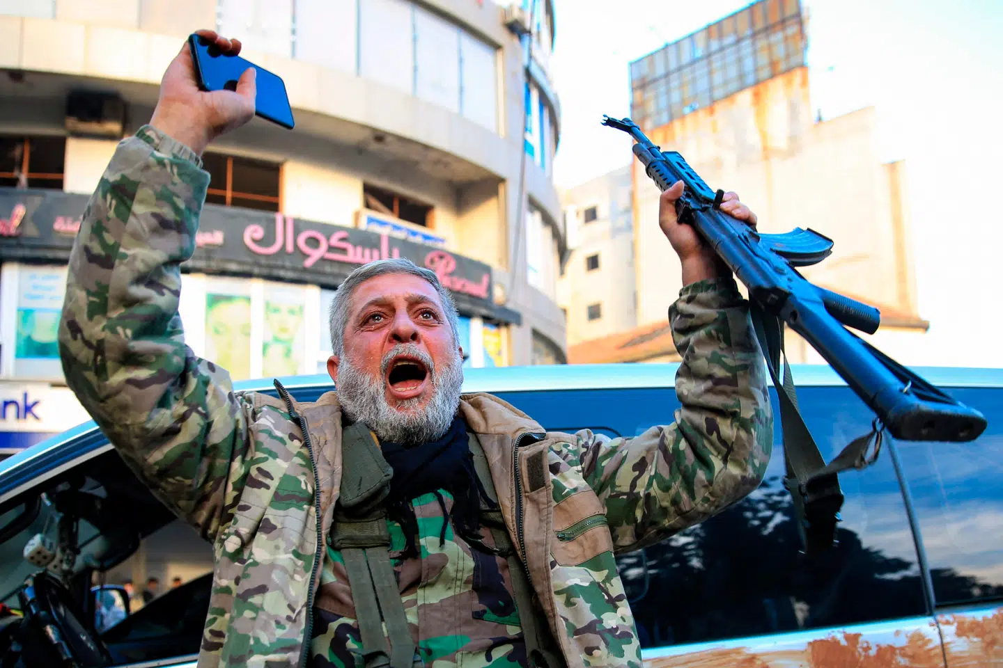 En soldat fra de syriske oprørsstyrker fejrer sejren over al-Assad-regimet i byen Homs.