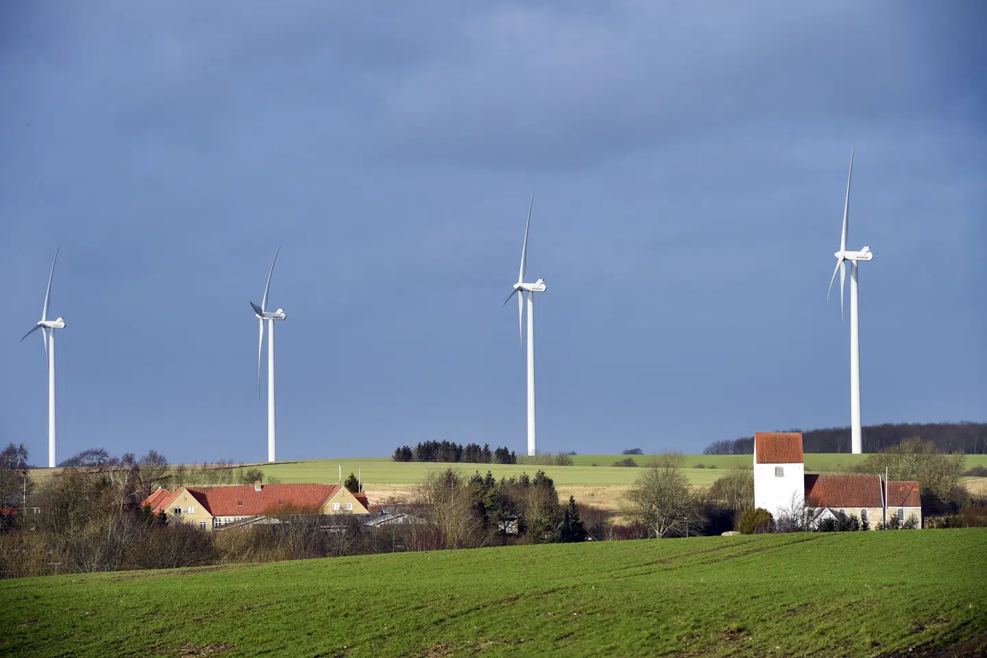 Tvede Kirke ved Randers med vindmøller i baggrunden. Folkekirken har i planloven en særlig indsigelsesret, når der skal bygges vindmøller inden for 1000 meters afstand af en kirke. (Arkivfoto).