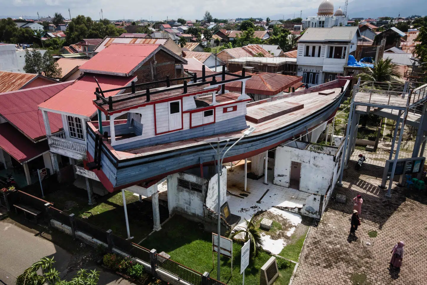 En båd ligger fortsat oven på et hus i Banda Aceh i Indonesien, efter at den blev skyllet derop under tsunamien i 2004. Over 226.000 mennesker omkom i flodbølgen.