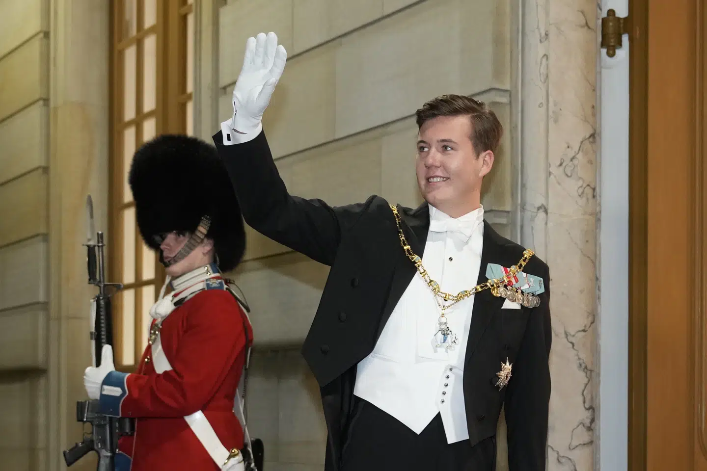 Kronprins Christian vender sig om og vinker til de fremmødte på Amalienborg Slotsplads, før han går ind til sin første nytårskur.