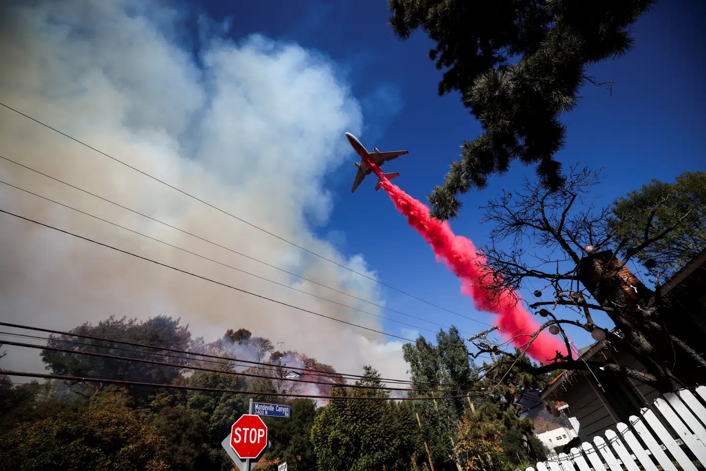Et fly kaster lyserødt brandhæmmende stof ud ved Mandeville Canyon i Los Angeles. Det ligger i den nordlige kant af den største af brandene, Palisades-branden, som fortsat ikke er under kontrol.