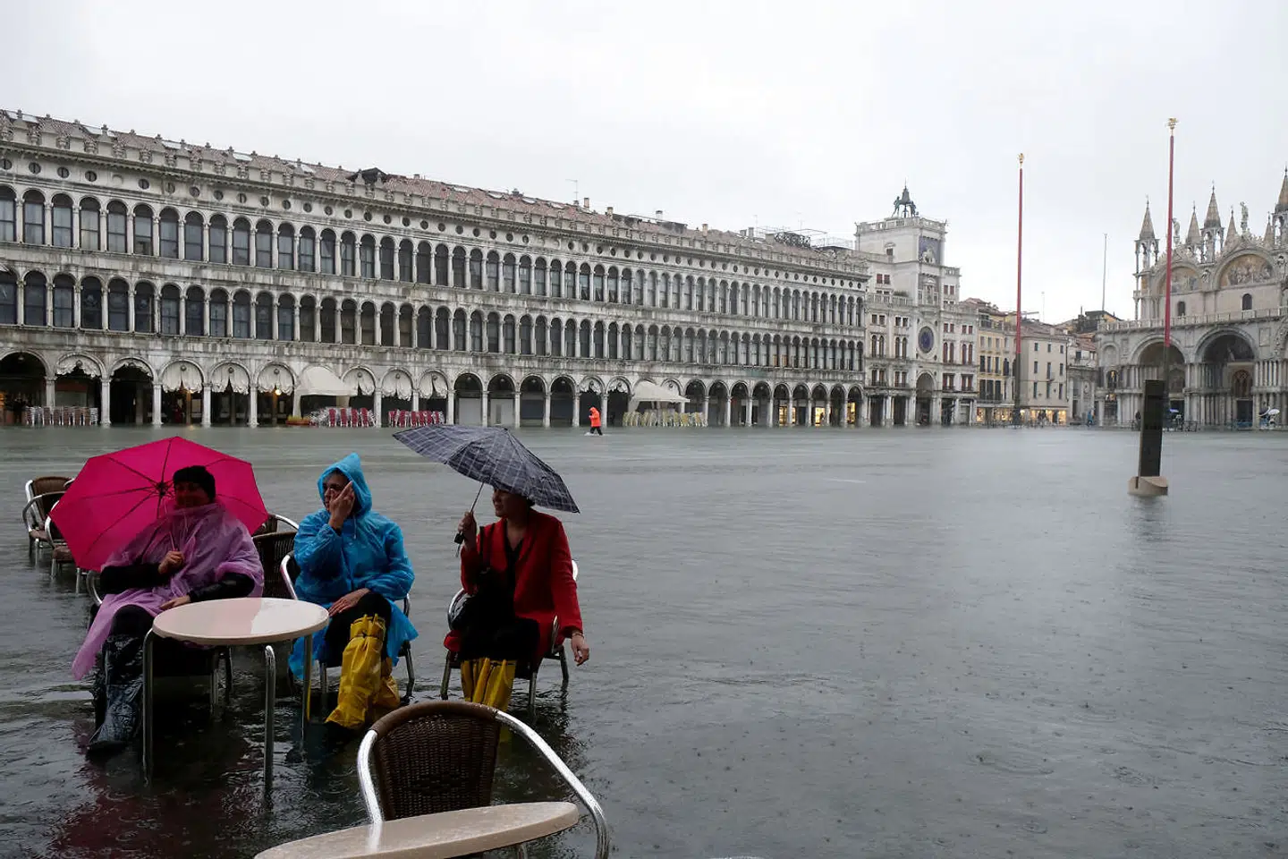 Turister ved en oversvømmet café på Markuspladsen.