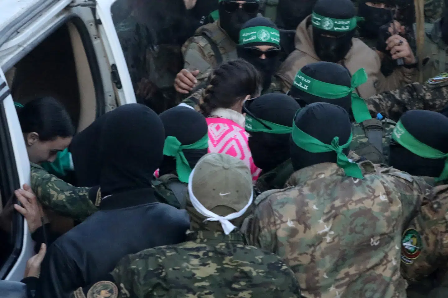 De tre kvindelige israelske gidsler ses her omringet af maskerede Hamas-krigere i Gaza By, hvor de søndag eftermiddag blev overdraget til Røde Kors' udsendinge.