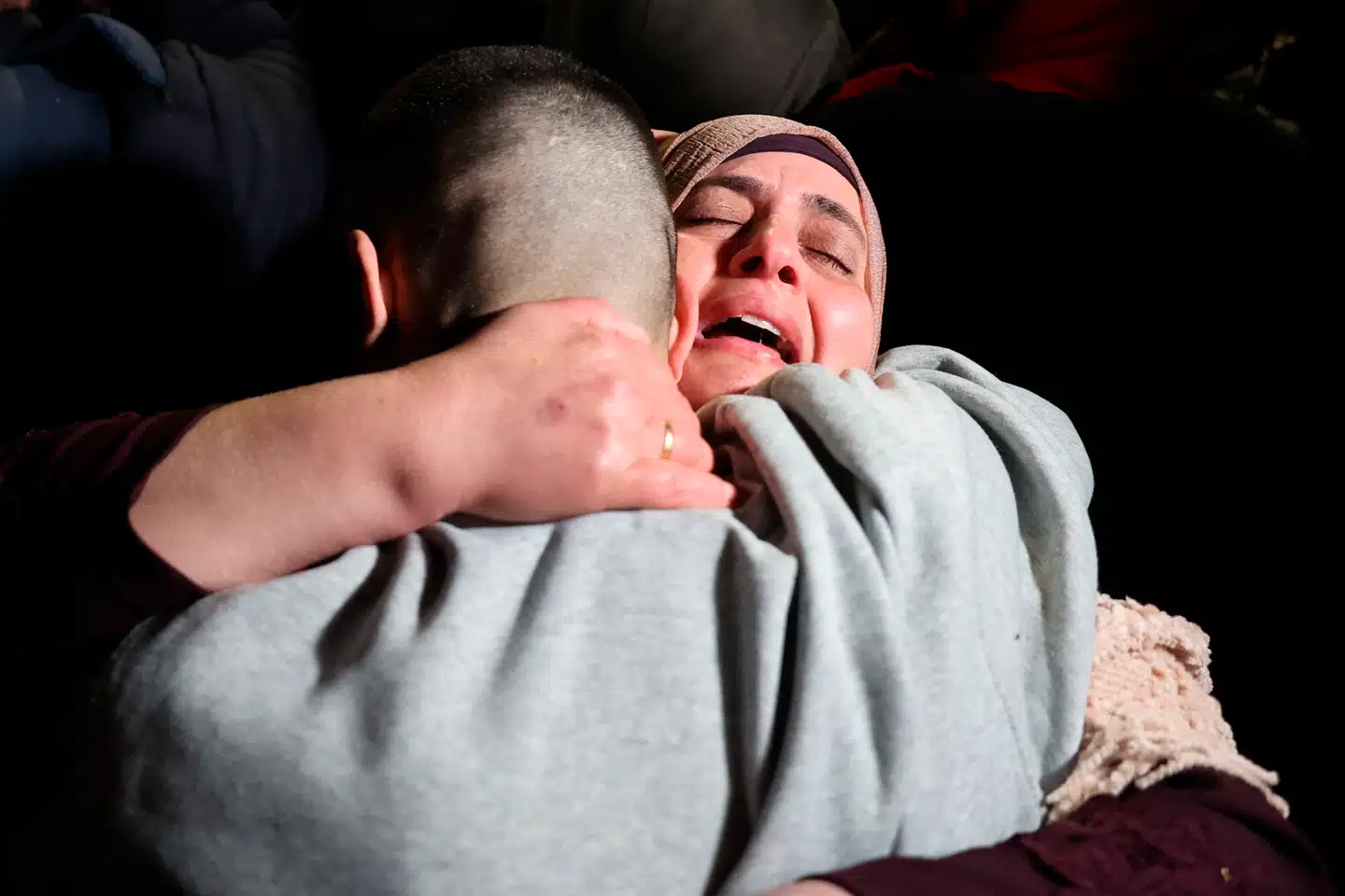 En palæstinensisk kvinde genforenes med sin søn, der er blevet frigivet fra israelsk fængsling søndag.