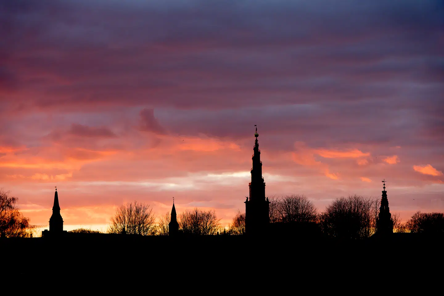 Solnedgang over København og byens tårne set fra Kløvermarken på Amager. Blandt andet ses Vor Frelsers Kirkes tårn, som er blandt Lauritz de Thurahs absolutte mesterværker.