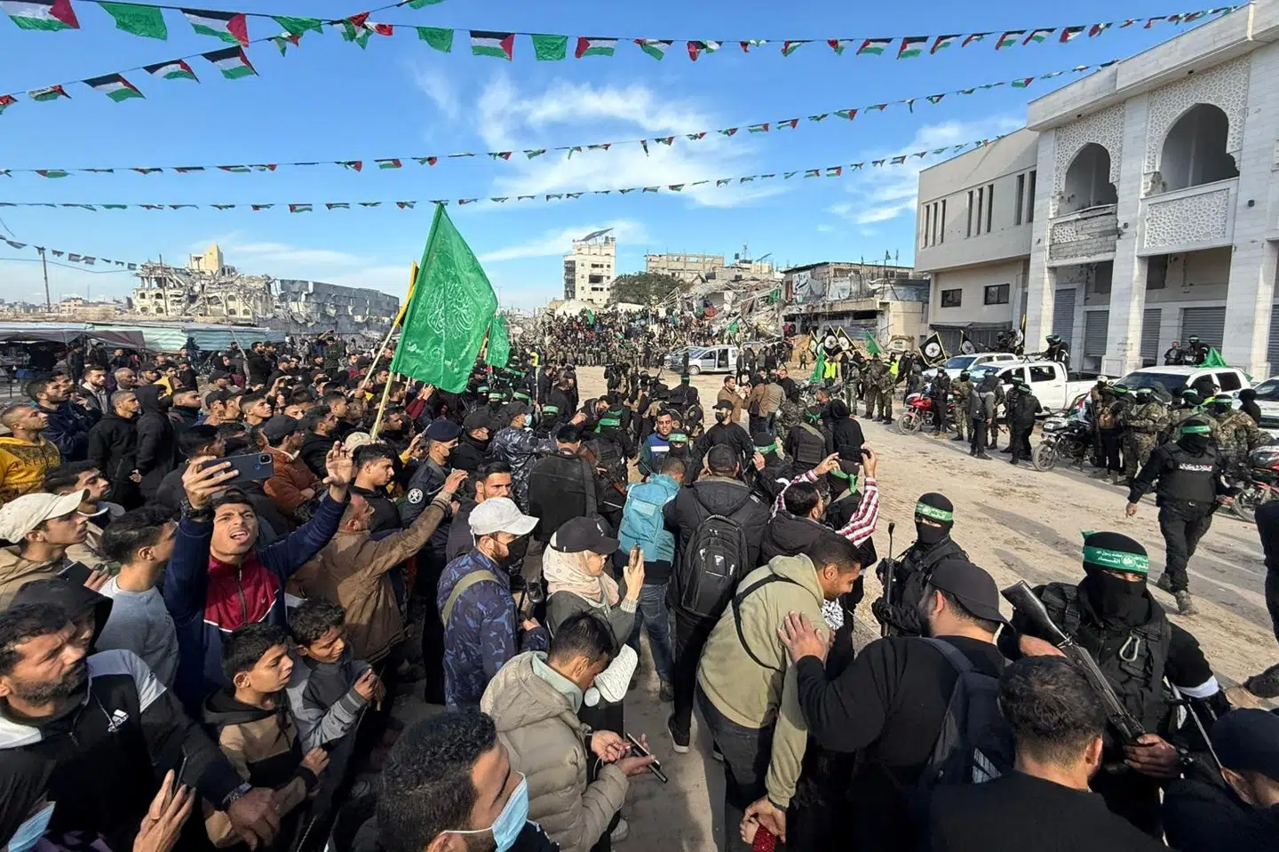 Indbyggere i Gaza By stimler sammen for at overvære overdragelsen af gidsler. Snesevis af bevæbnede medlemmer af Hamas og Islamisk Jihad er til stede.