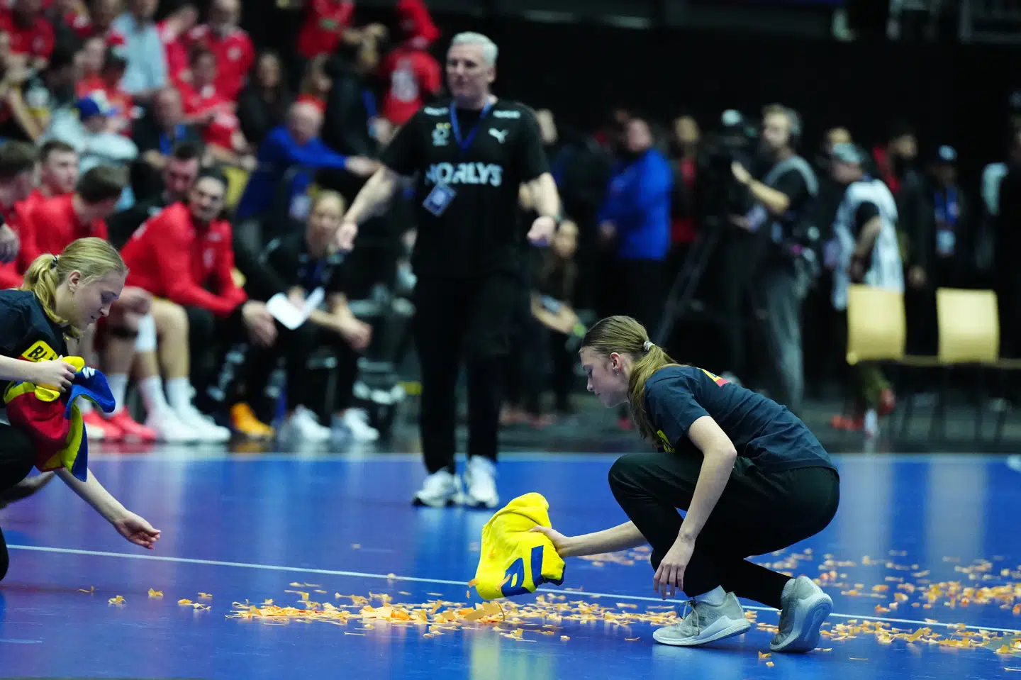 Konfetti bliver fjernet fra banen, hvor lørdagens håndboldkamp kortvarigt blev afbrudt, fordi en mand løb ind på banen og kastede de farverige papirstrimler.