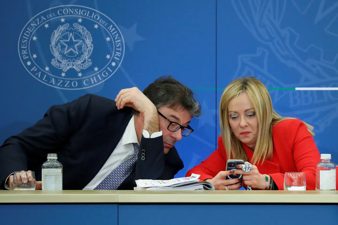 Giorgia Meloni tjekker mobilen side om side med finansminister Giancarlo Giorgetti under præsentationen af den højrenationale koalitionsregerings første finanslov i 2022. Men det er næppe for sidste nyt på hendes partis interne chat. Giorgetti tilhører partiet Lega, hvis leder, Matteo Salvini, er mål for perfide personangreb i chatten, afslører en ny bog.