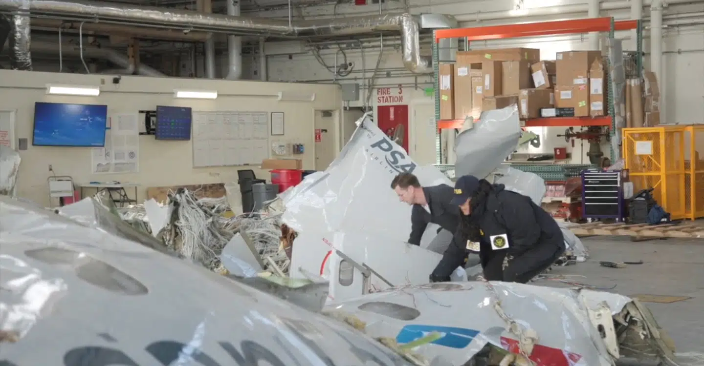 Ansatte hos den amerikanske transportmyndighed National Transportation Safety Board (NTSB) ses her undersøge vragdelene fra kollisionen mellem passagerflyet og en Black Hawk-helikopter. Vragdelene opbevares i en hangar på et ukendt sted.