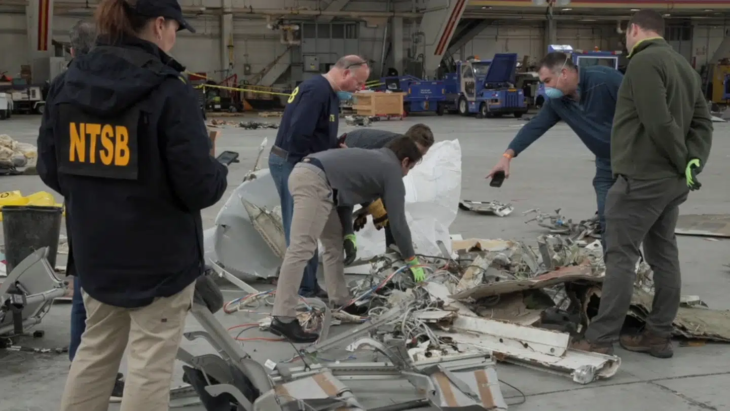 Ansatte hos den amerikanske transportmyndighed National Transportation Safety Board (NTSB) ses her undersøge vragdelene fra kollisionen mellem passagerflyet og en Black Hawk-helikopter. Vragdelene opbevares i en hangar på et ukendt sted.
