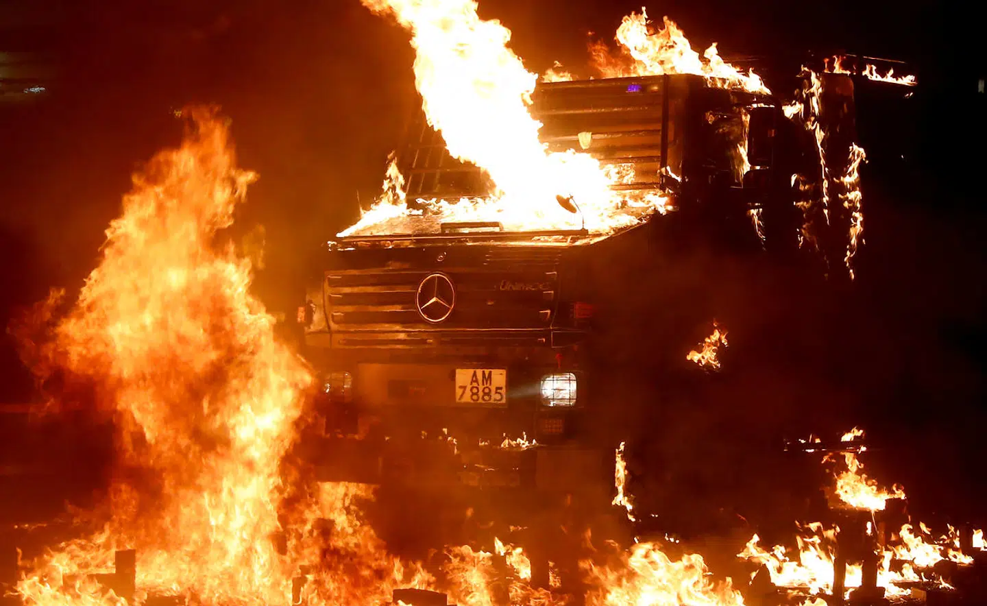 A police vehicle catches fire after being hit with molotov cocktails, as anti-government protesters clash with police, outside Hong Kong Polytechnic University (PolyU) in Hong Kong, China, November 17, 2019. REUTERS/Athit Perawongmetha