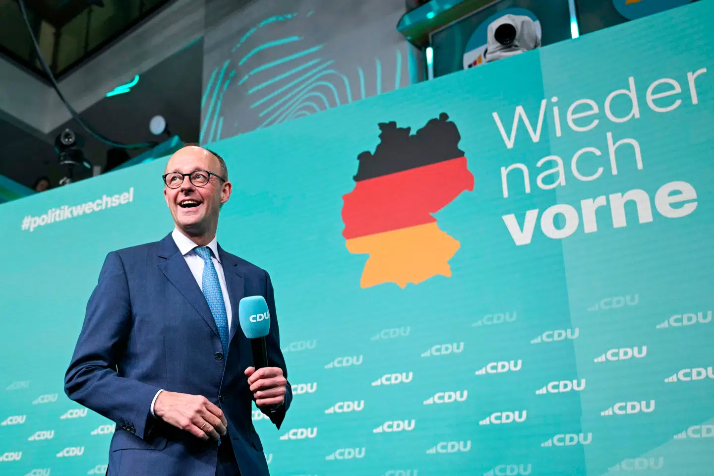 En glad Friedrich Merz på scenen på valgaftenen.