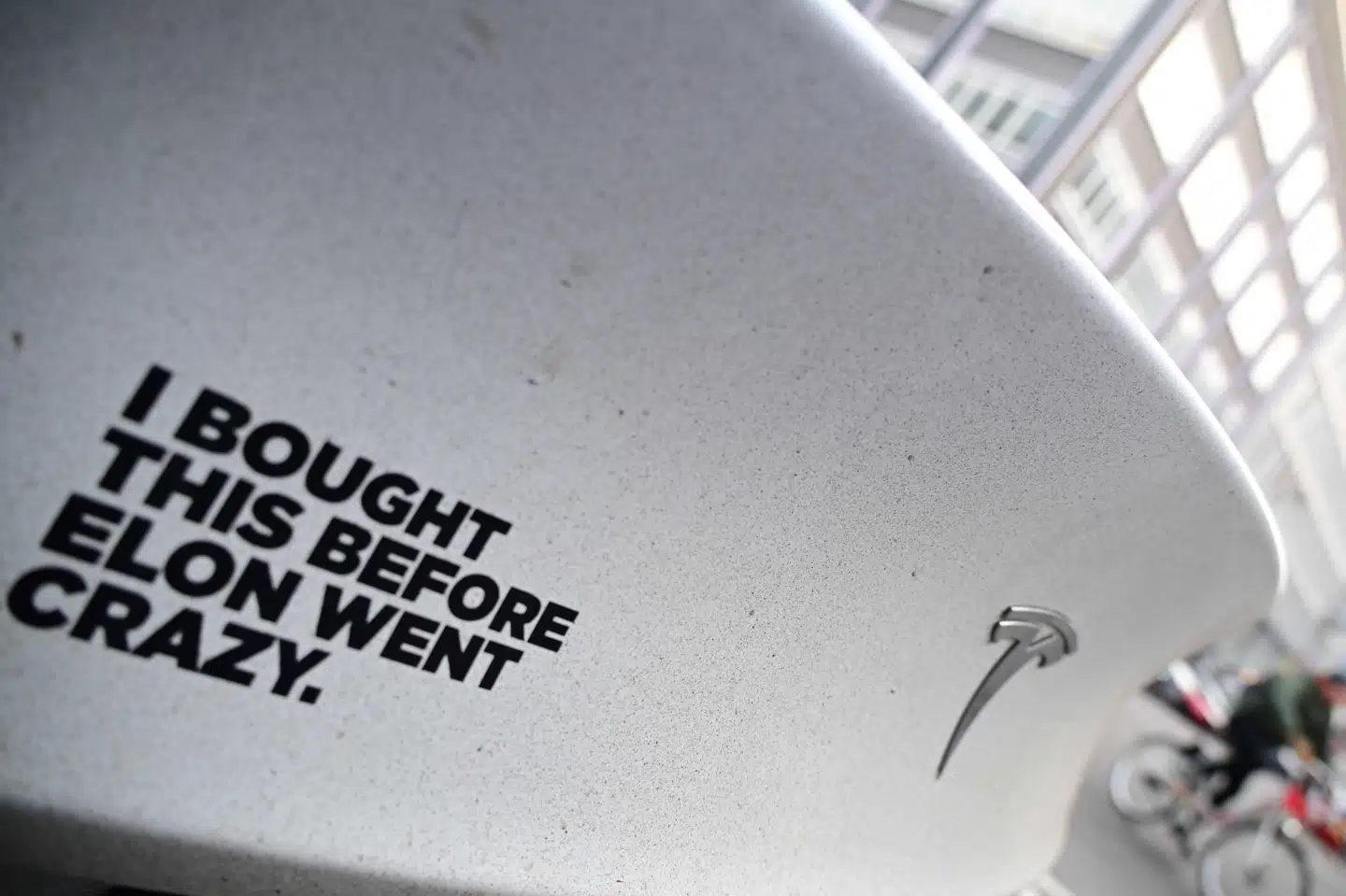 Et mærkat bag på en Tesla elbil i Tyskland proklamerer, at bilen er købt, "inden Elon blev skør". I januar faldt salget af Teslaer i Europa med omkring 45 procent sammenlignet med januar 2024.
