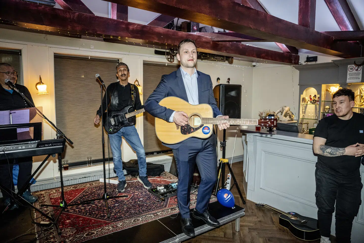 Det spiller i den grad for formanden for Demokraatit, Jens-Frederik Nielsen, som her ses med en guitar i hånden under valgfest tirsdag aften i Nuuk.
