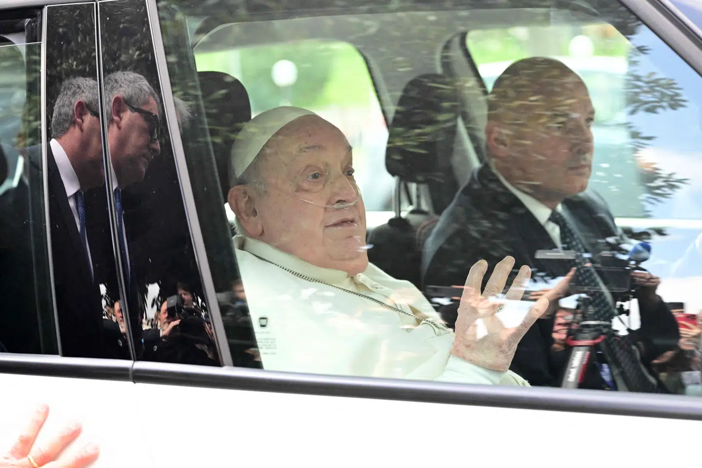 Pave Frans vinker fra en bil, da han søndag bliver kørt væk fra Gemelli-hospitalet i Rom.