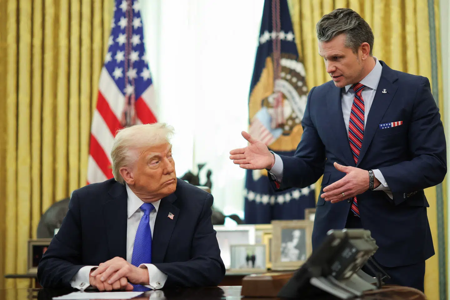 Her ses forsvarsminister Pete Hegseth i samtale med USAs præsident, Donald Trump.