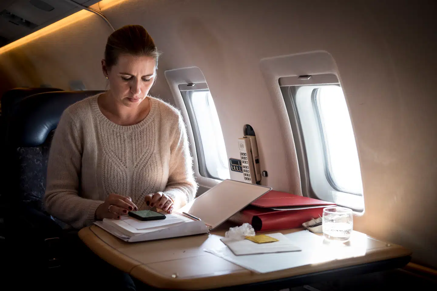 Statsminister Mette Frederiksen havde ikke været statsminister i mere end halvanden måned, før hun første gang måtte forsvare Grønland imod Donald Trumps tilnærmelser. Her ses hun i flyet, få timer før hun i august 2019 kaldte Trumps købstilbud for »absurd«. Onsdag lander hun igen i Nuuk under voldsomt amerikansk pres.