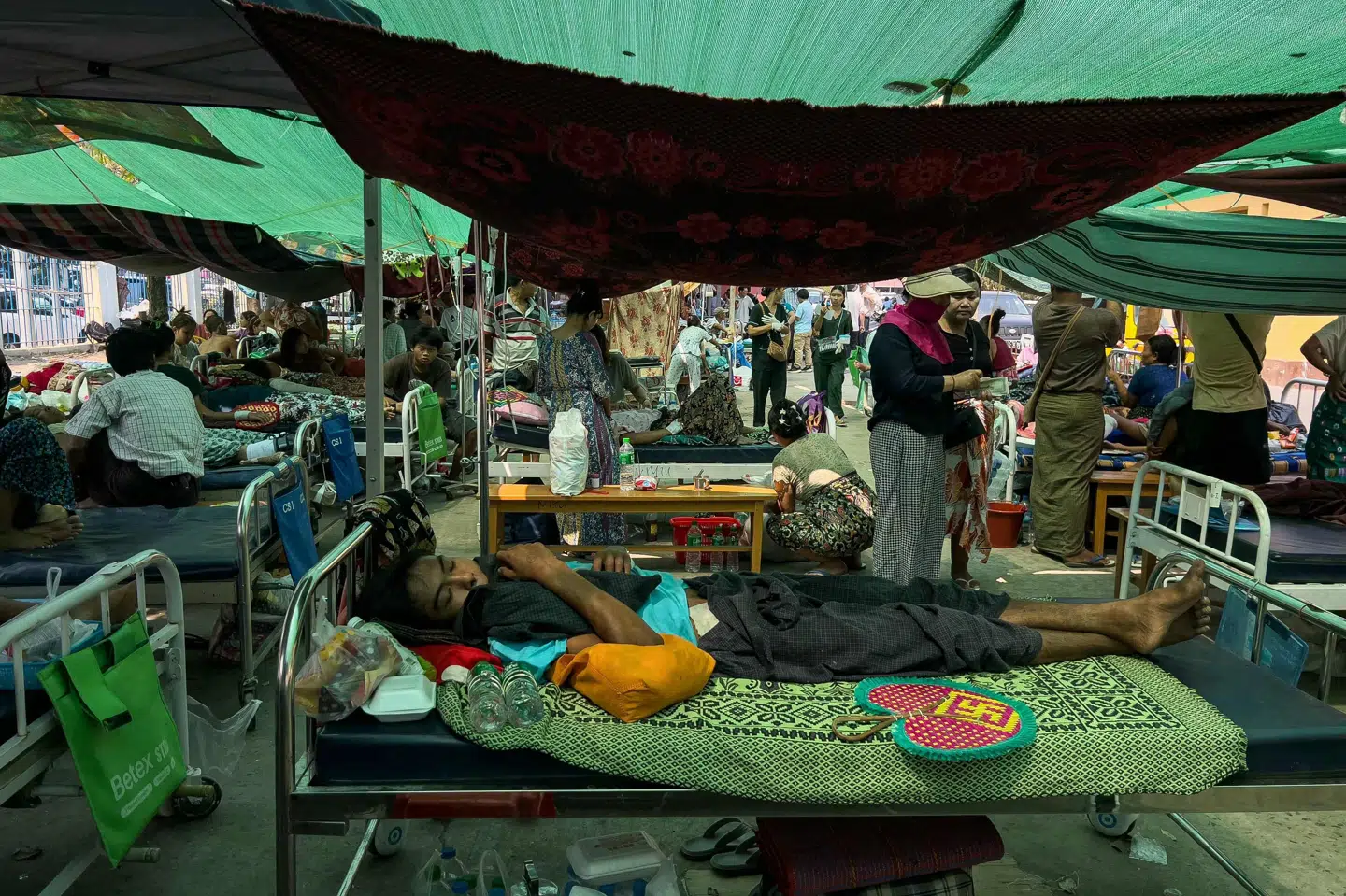 Patienter ligger på gaden ved et hospital i Myanmar efter et voldsomt jordskælv, der ramte landet fredag.