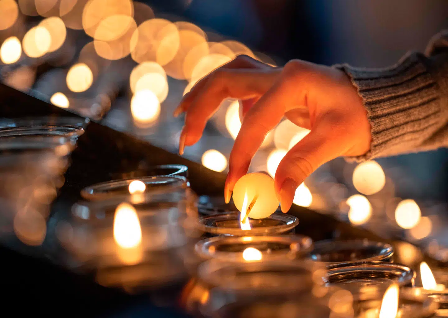 En kvinde tænder et lys i Stefans-katedralen 14. april 2025 forud for langfredag.