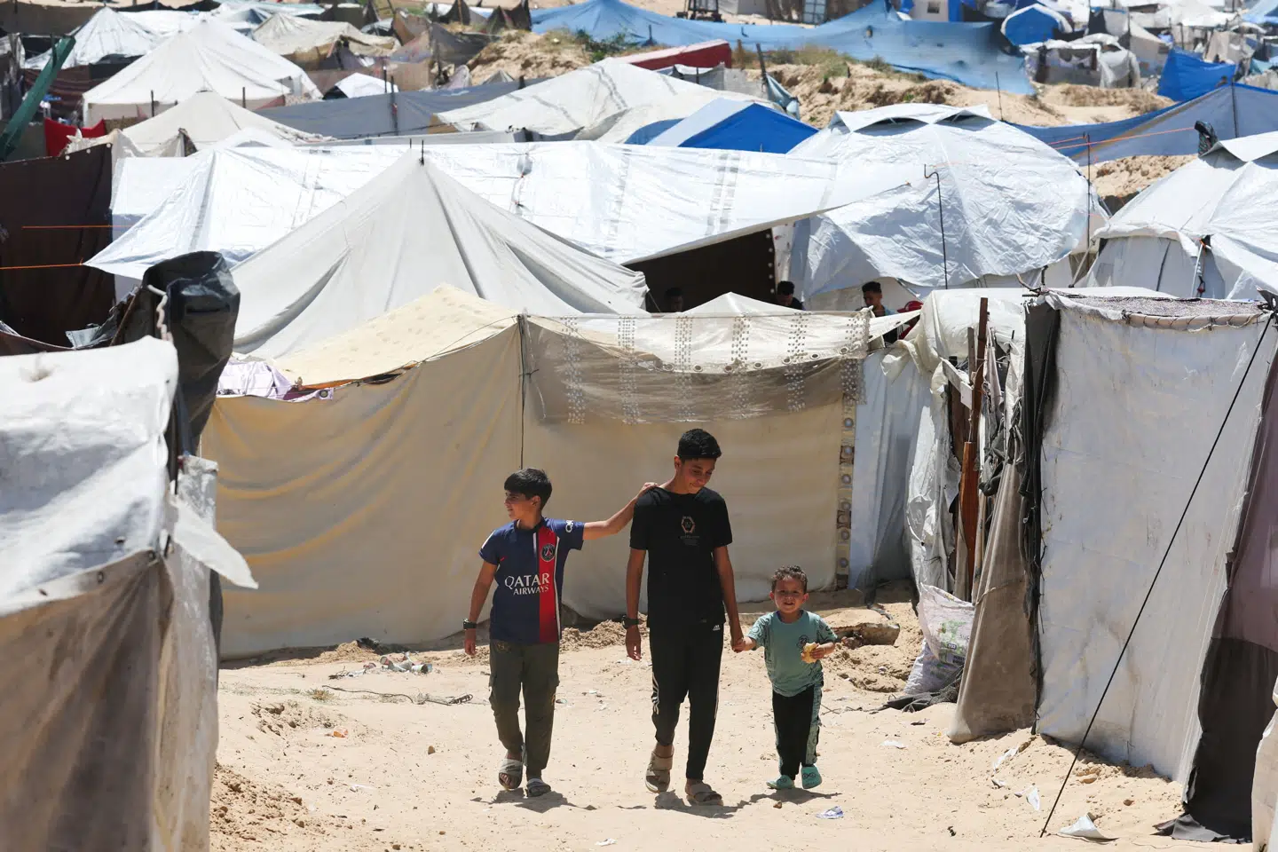 Tre børn går gennem en teltlejr ved byen Khan Younis i det sydlige Gaza, hvor et stort antal fordrevne palæstinensere opholder sig.